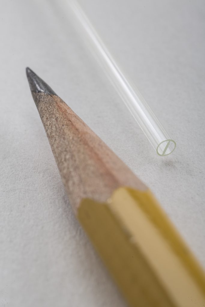 multi-lumen tube with double D design next to pencil tip for size comparison