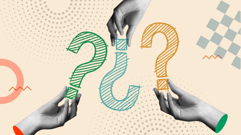 Human hands holding question marks
